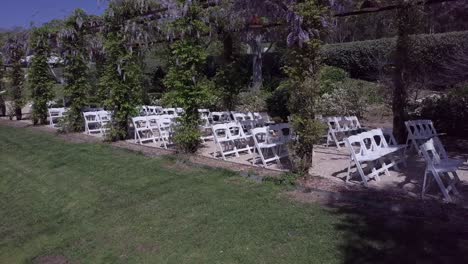 rows of white folding chairs on the lawn before the arrival of guests - drone, wideshot