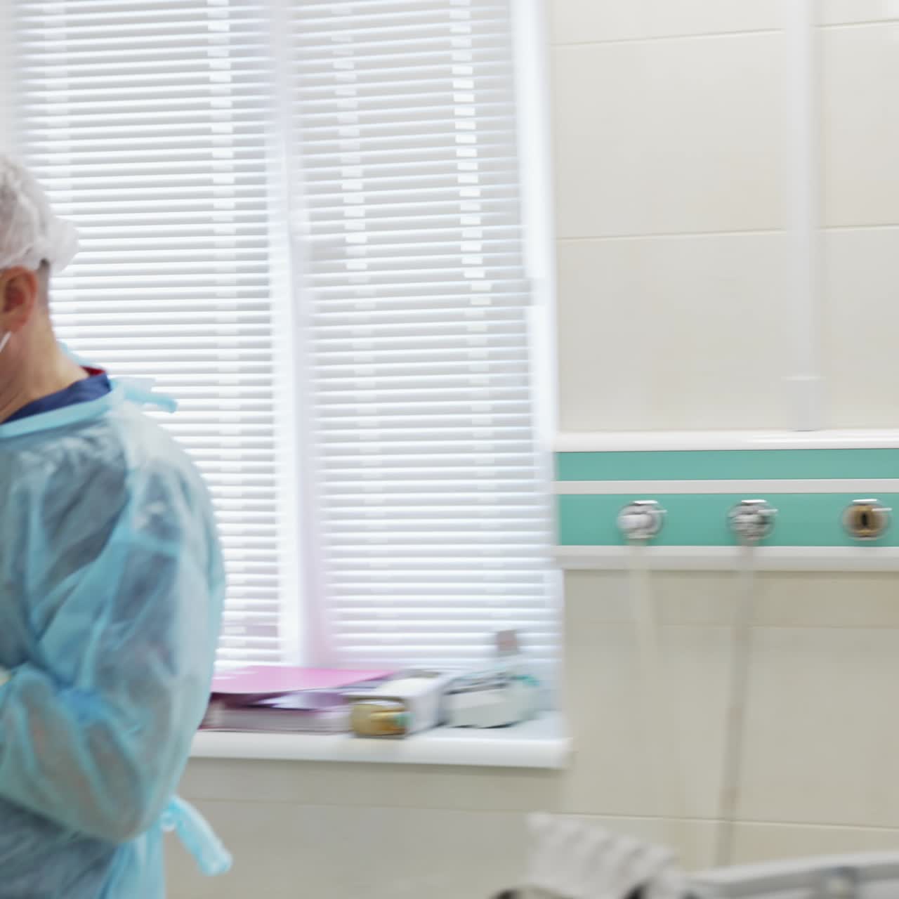 Medical specialists prepare for surgery. Assistant helping to wear a full protective clothes for the doctor before start of a surgical operation
