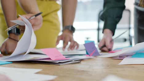 Mid-Section-Of-Colleagues-Working-On-Project-At-Table