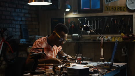 man working on a small robot in a garage