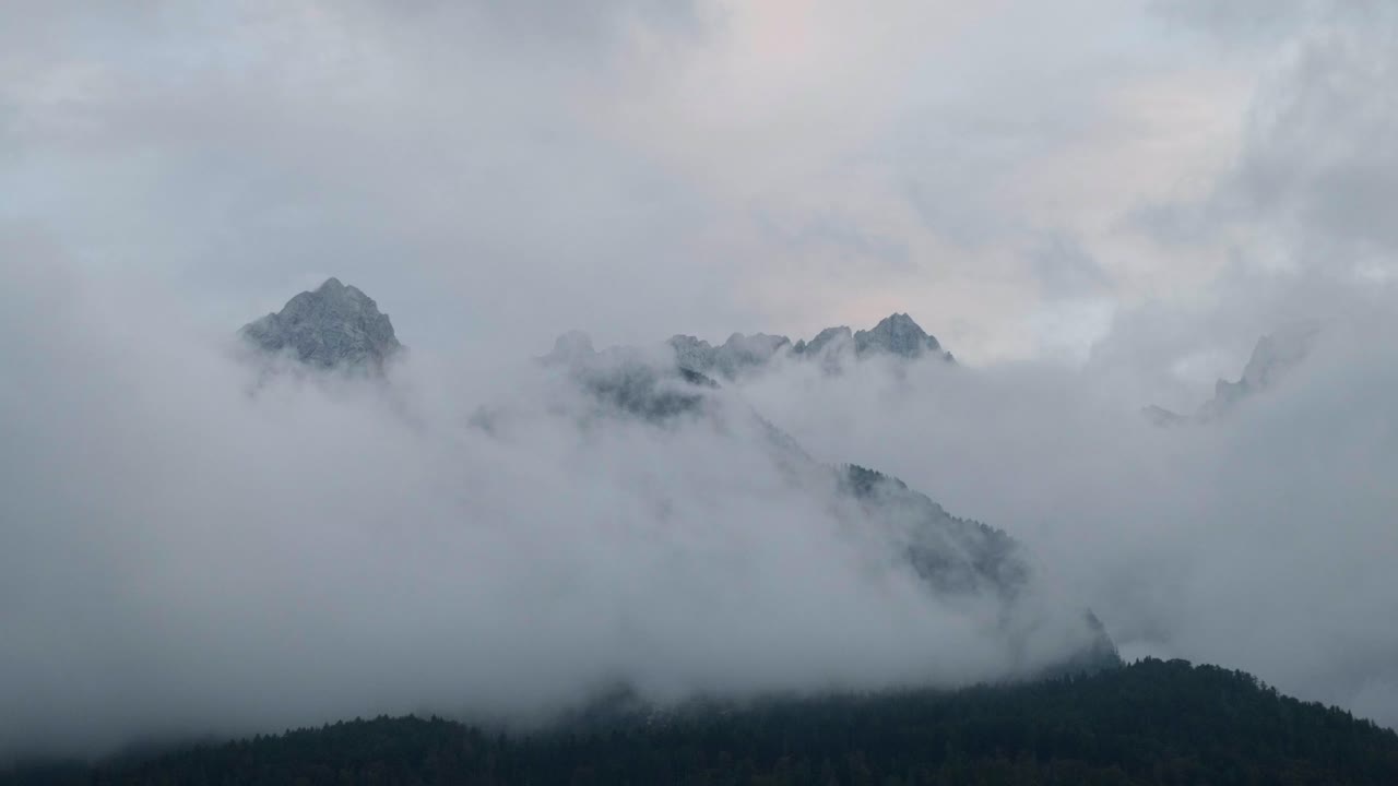 일몰 동안 슬로베니아 트리글라브 국립공원의 산 정상을 껴안고 있는 구름