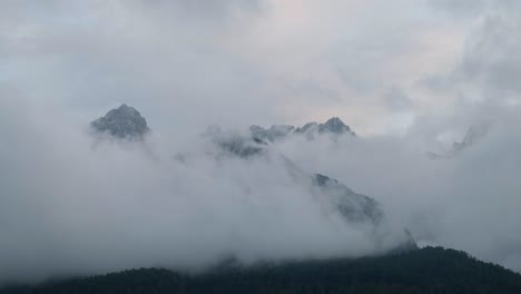 nubes abrazando las cumbres de las montañas en el parque nacional triglav en eslovenia durante la puesta de sol