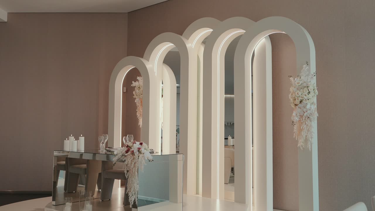 illuminated arched mirrors with soft floral accents in a refined pastel-toned interior space