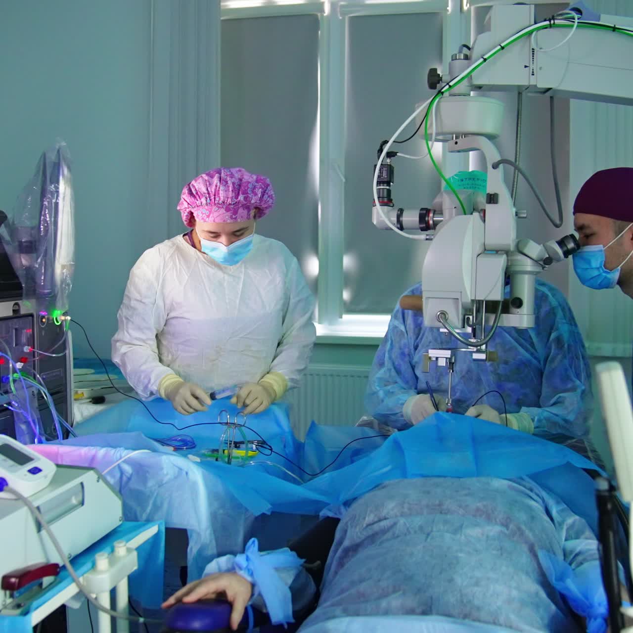 Operational room in ophthalmic clinics. Surgery in process conducted by male doctors with female nurse's assistance