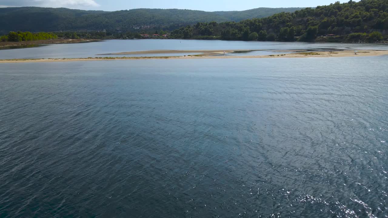 그리스 북부 할키디키(halkidiki) 보우부루(vourvourou) 만의 모래섬과 얕은 물 위로 움직이는 영화 같은 드론 클립