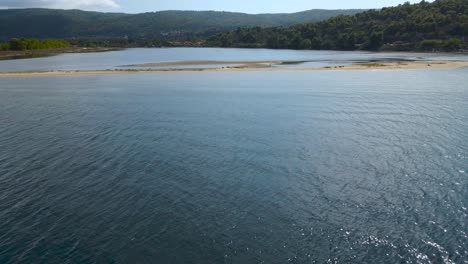 Filmischer-Drohnenclip,-Der-Sich-über-Sandige-Inseln-Und-Seichtes-Wasser-In-Der-Bucht-Von-Vourvourou,-Chalkidiki,-Nordgriechenland,-Bewegt