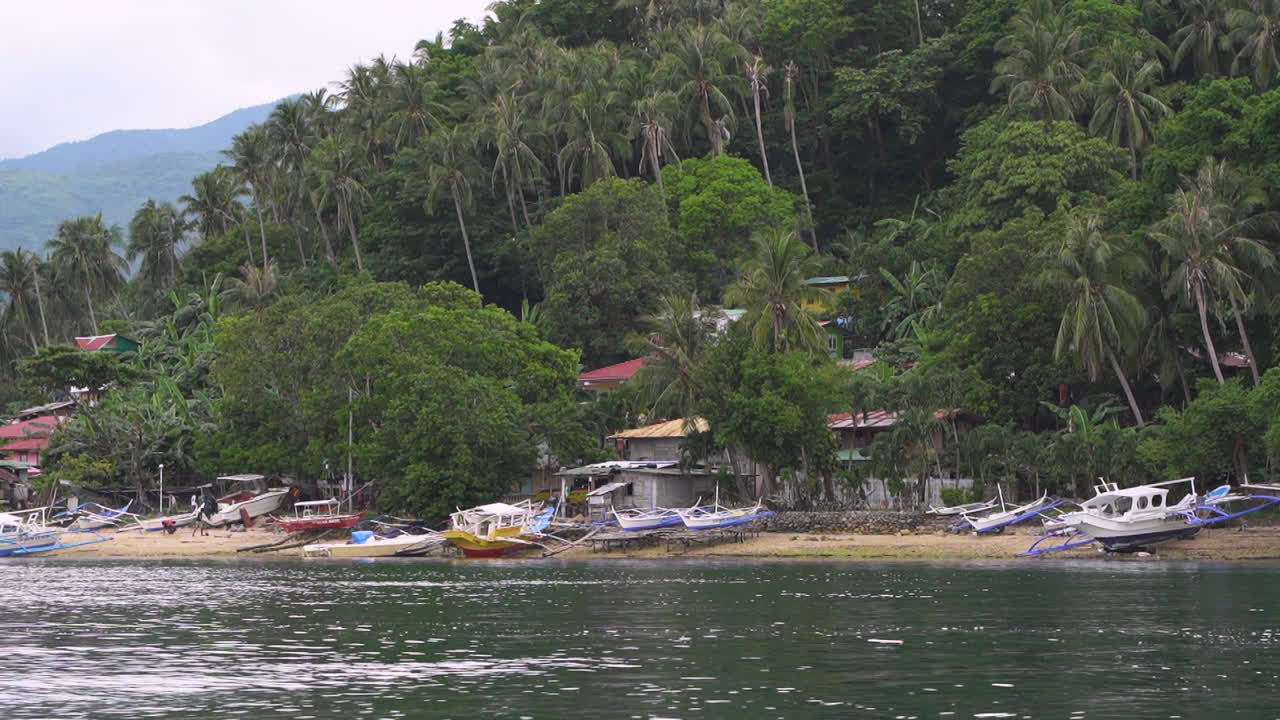 vista desde un barco que entra en una isla de pequeños barcos pesqueros estacionados en la playa