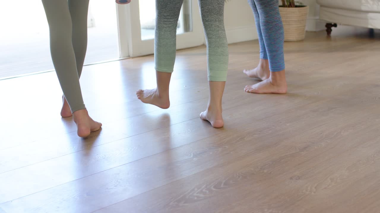 Amigas diversas terminando o aquecimento, caminhando em direção às portas de vidro e recolhendo tapetes de ioga