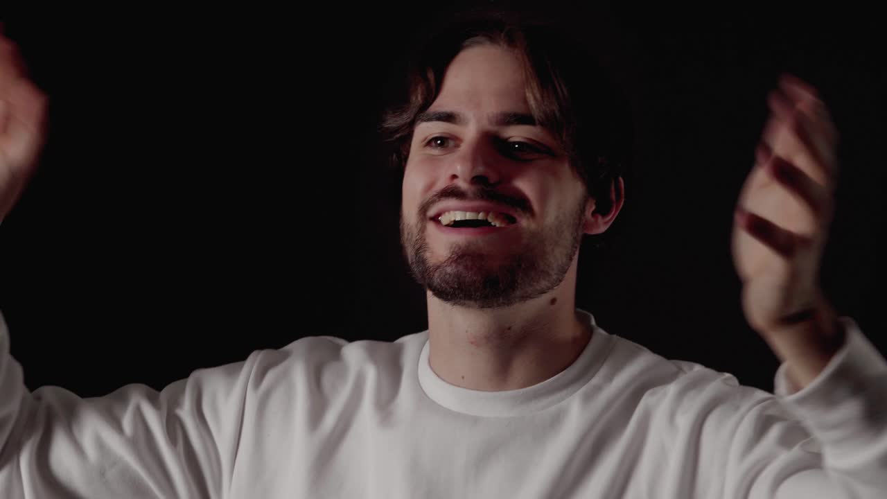 양손으로 카메라를 향해 손을 흔드는 트렌디한 청년, 가까이, 검은색 배경