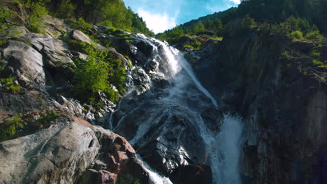 Cinematic-rising-aerial-shot-of-a-small-waterfall-in-Switzerland