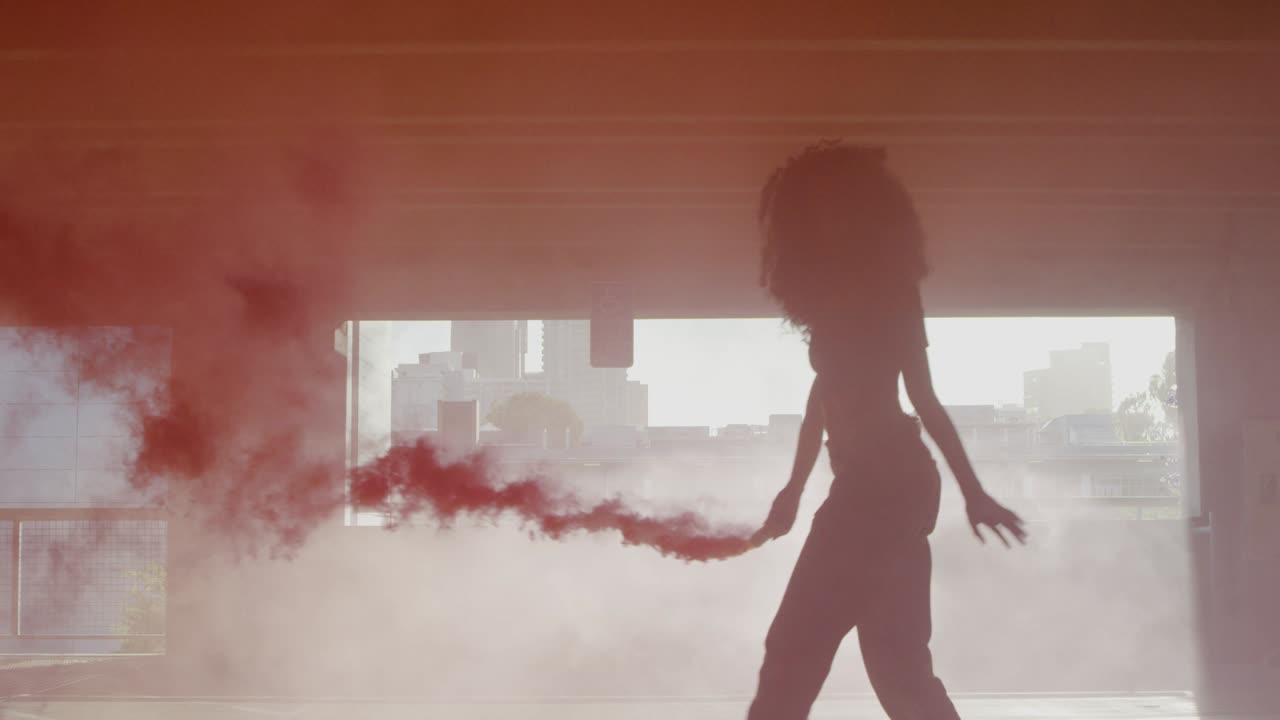 실루 젊은 여성이 주차장에서 다채로운 은 연기 폭탄으로 춤을 춘다