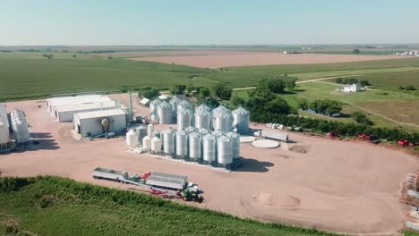 Vista-Aérea-De-Los-Recipientes-De-Almacenamiento,-Almacenes,-Tractores-Y-Remolques-De-Una-Agroindustria-De-Semillas-De-Cobertura-En-Nebraska,-Ee-4