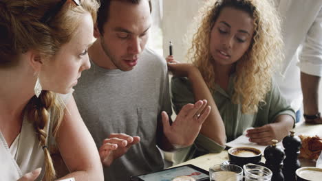 reunión de inicio de pequeñas empresas en un café compartiendo dispositivos de pantalla táctil