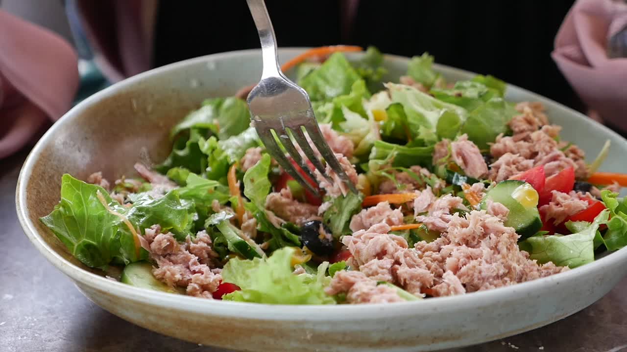 Persona comiendo ensalada de atún