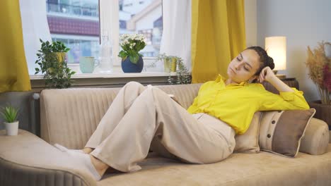 happy young woman lying on the sofa. she is resting.