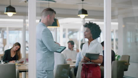 Hombre-De-Negocios-Conversando-Con-Una-Pasante-Discutiendo-Los-Datos-Del-Proyecto-En-Una-Tableta-Informando-A-Un-Asistente-Personal-Que-Comparte-La-Estrategia-De-Desarrollo-En-Una-Oficina-Moderna-4k