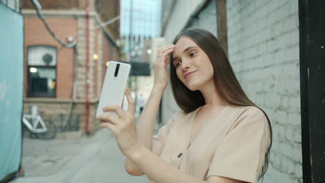 woman taking selfie in a city alley
