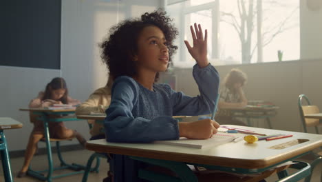 kid studying science at elementary school. girl sitting at desk in classroom