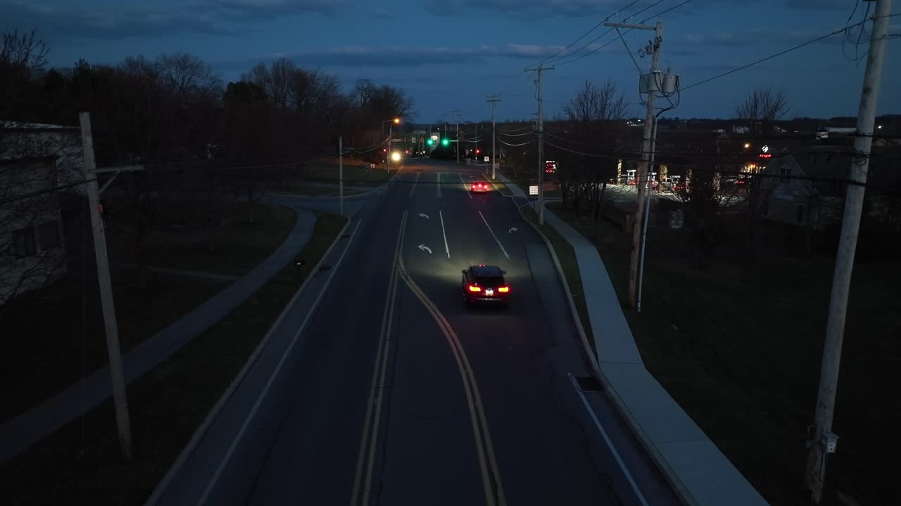 저녁 어 ⁇ 에 헤드라이트와 조명이 켜져 있는 자동차가 밤에 도로에서 빨리 달리고 있습니다.