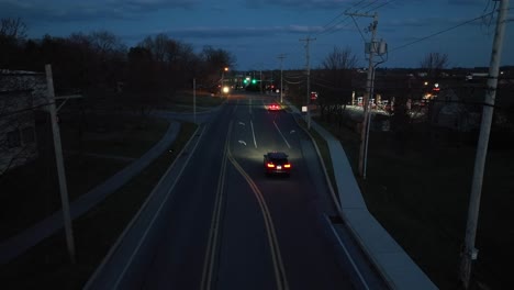 Cars-driving-fast-on-road-at-night-with-headlights-and-lights-on-in-evening-darkness