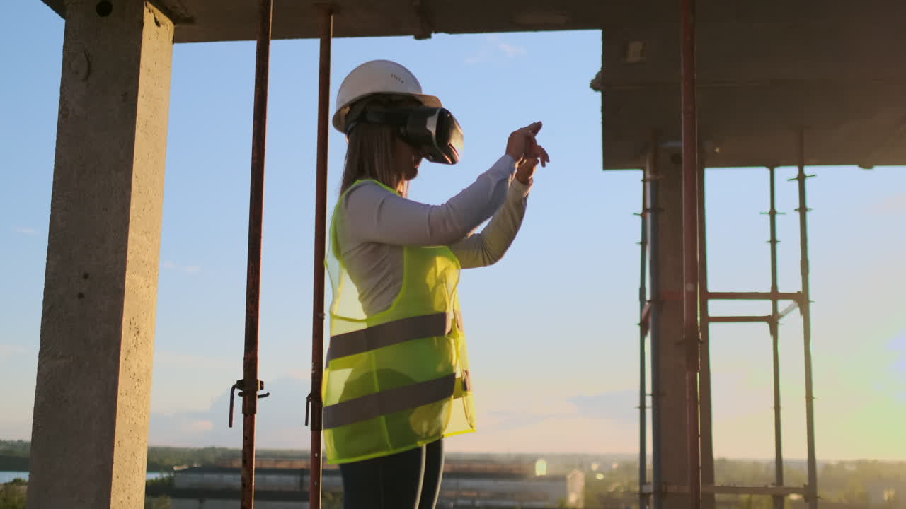 inspector mujer en gafas vr y casco comprueba el progreso de la construcción de un rascacielos moviendo sus manos al atardecer visualizando el plan del edificio