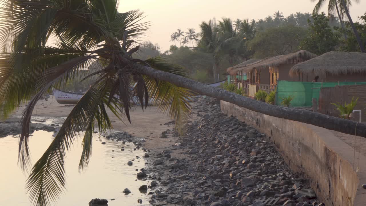 toma panorámica a través de la fila de coloridas cabañas de playa con techo de paja en la costa de la playa de indian, goa