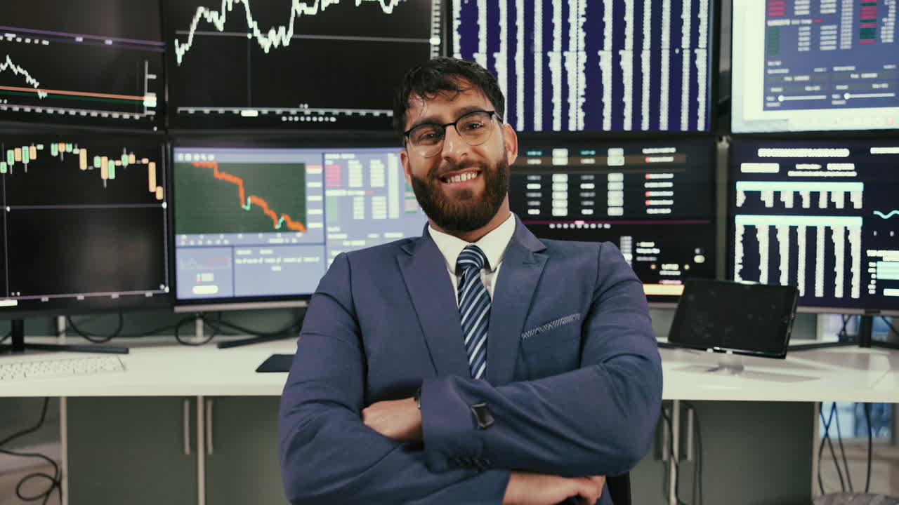Uomo d'affari in giacca e cravatta che osserva dati finanziari su monitor