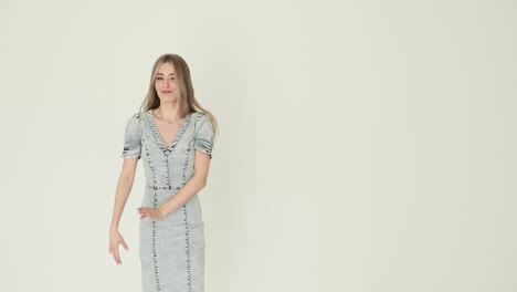 young woman in denim dress posing in a studio