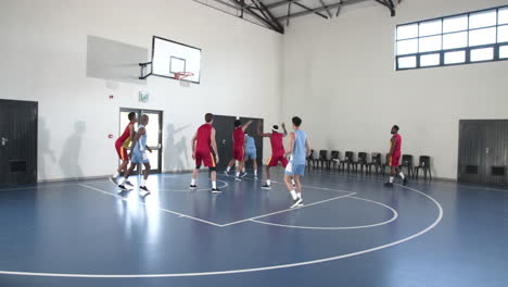 basketball players competing intensely on indoor court, aiming for hoop
