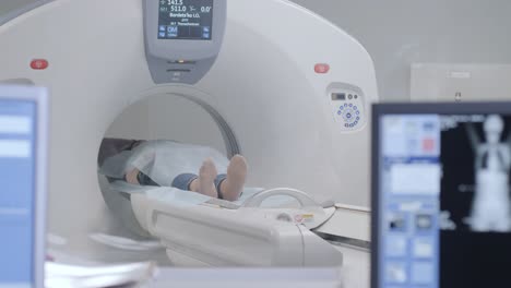 woman lying on the ct or mri scanner during machine imaging her body, lights up infrared rays and female patient passes through the circle, crane shot from down to up, room interior, active scene.