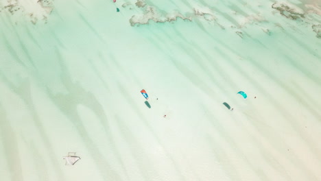 surfistas de cometas deslizándose sobre aguas cristalinas