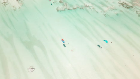 kite surfers gliding over crystal clear waters