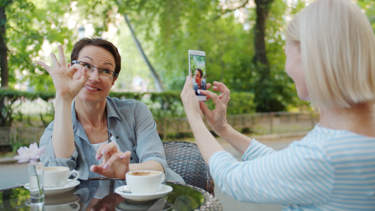 Two Women Friends Taking a Photo in a Cafe