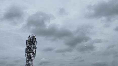 Low-angle-shot-of-telephone-tower-over-a-house-on-a-cloudy-day