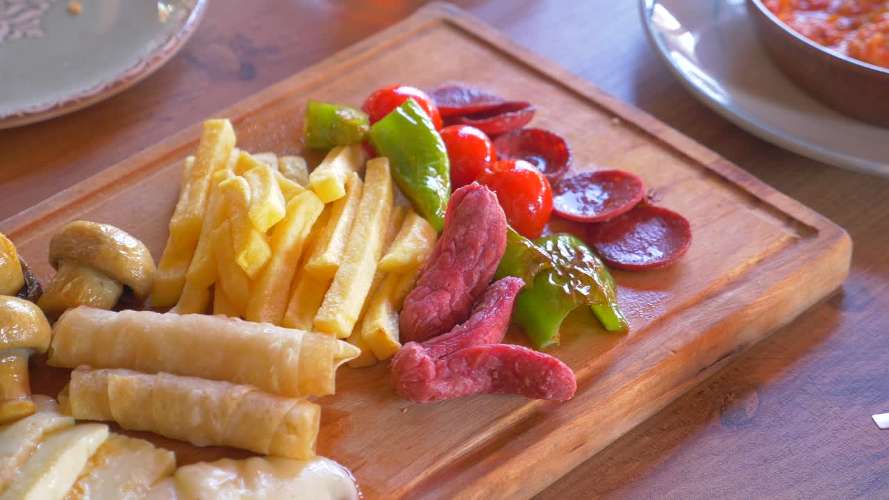 plato de desayuno turco con queso, salchichas, papas fritas y verduras