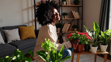 happy woman tending to and enjoying her houseplants