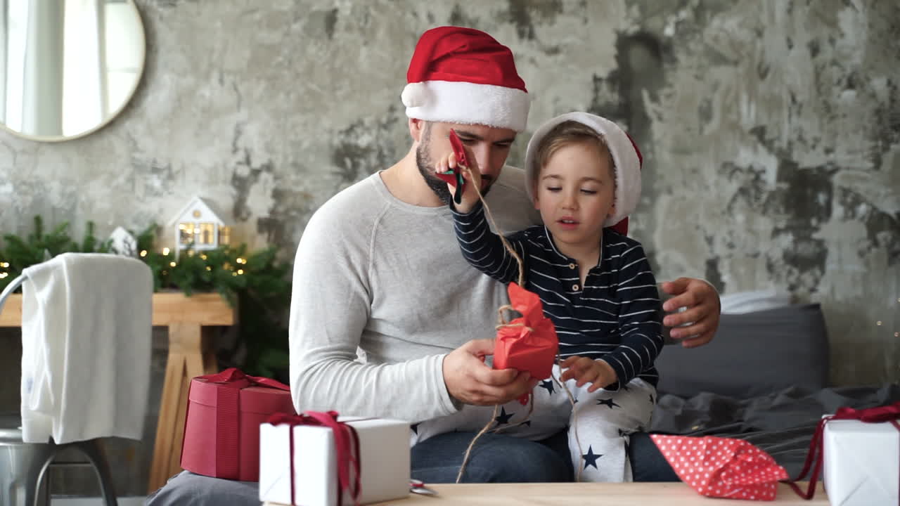 padre e hijo pequeño preparan regalos de navidad