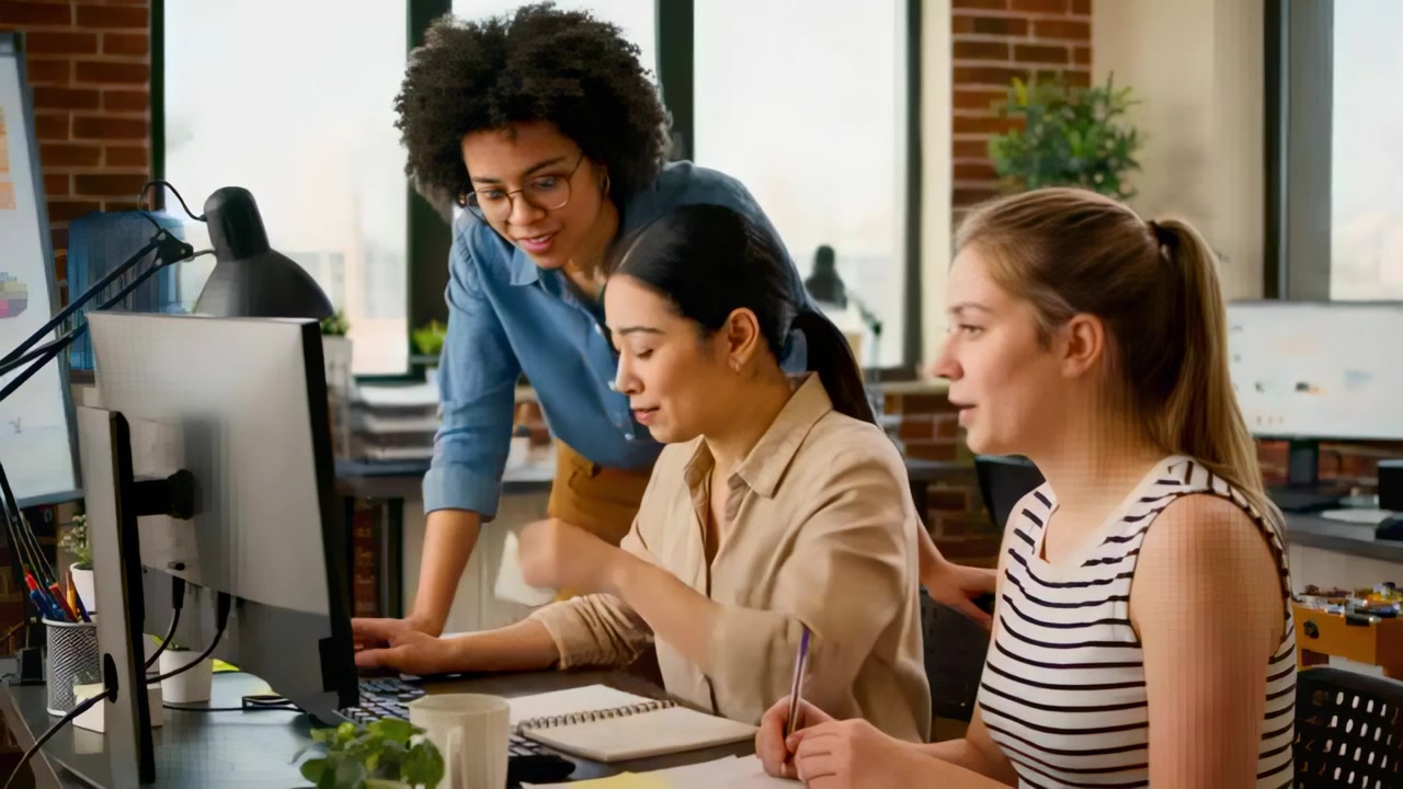 Pointing center woman in blouse referring to note, typing on keyboard at office monitor confirming