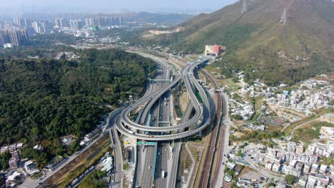 Verkehr-Auf-Einem-Massiven-Autobahnkreuz-Mit-Mehreren-Ebenen-Und-Schleifenförmiger-Straße-In-Hongkong,-Luftbild