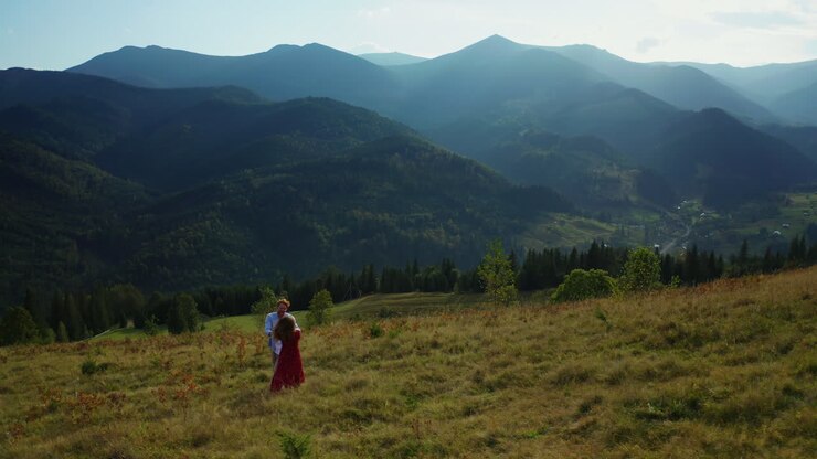 Young couple dancing against stunning hills panorama in a sunny day