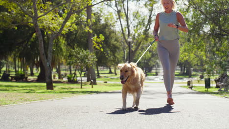 woman running with dog in park