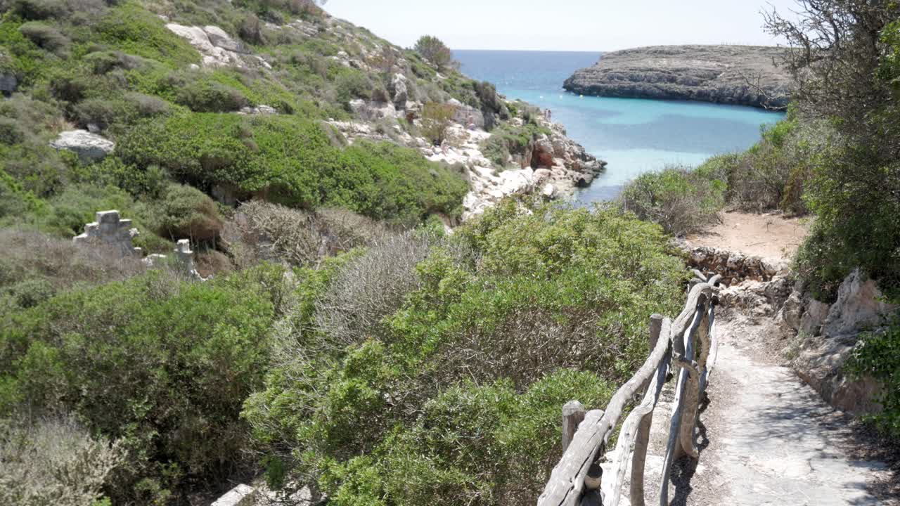 Cala Binidali Menorca, a scenic coastal path leading to the tranquil waters of the Mediterranean
