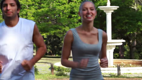 una pareja sonriente corre juntos a medida que pasa el tiempo y están más abajo en el camino.