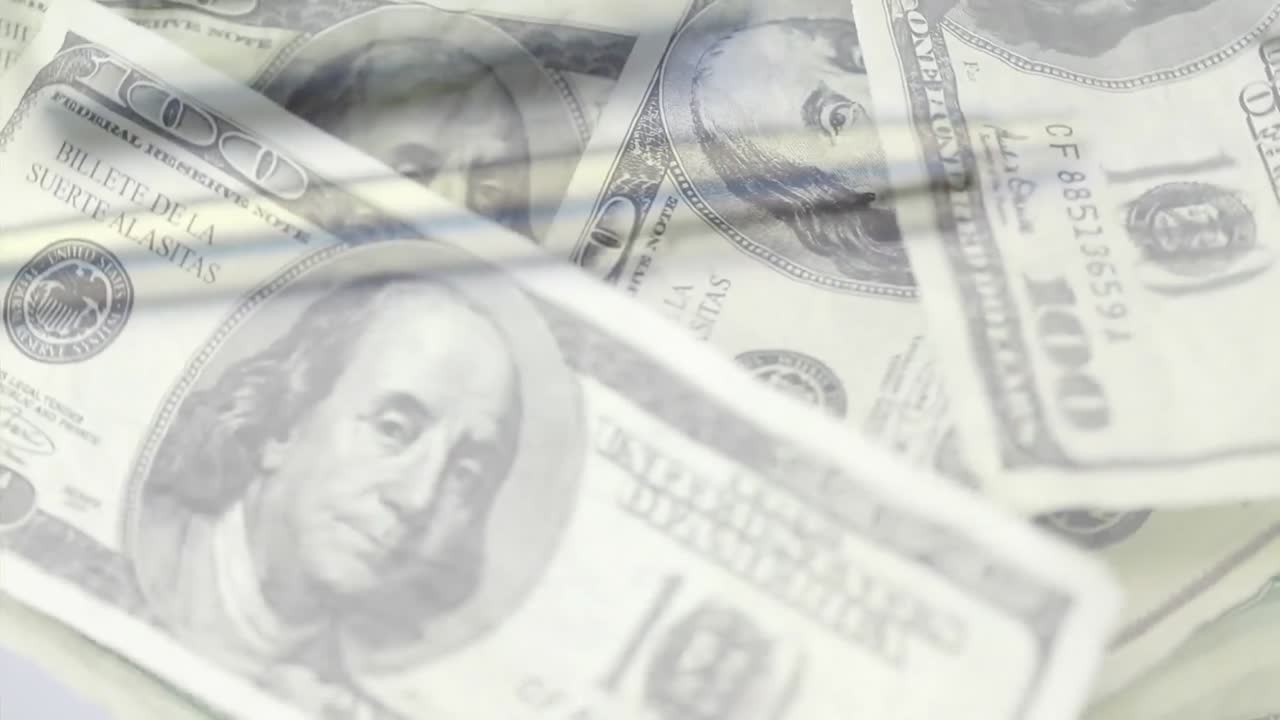 Animation af amerikanske dollar-sedler, lommeregner og en notesbog, der roterer.