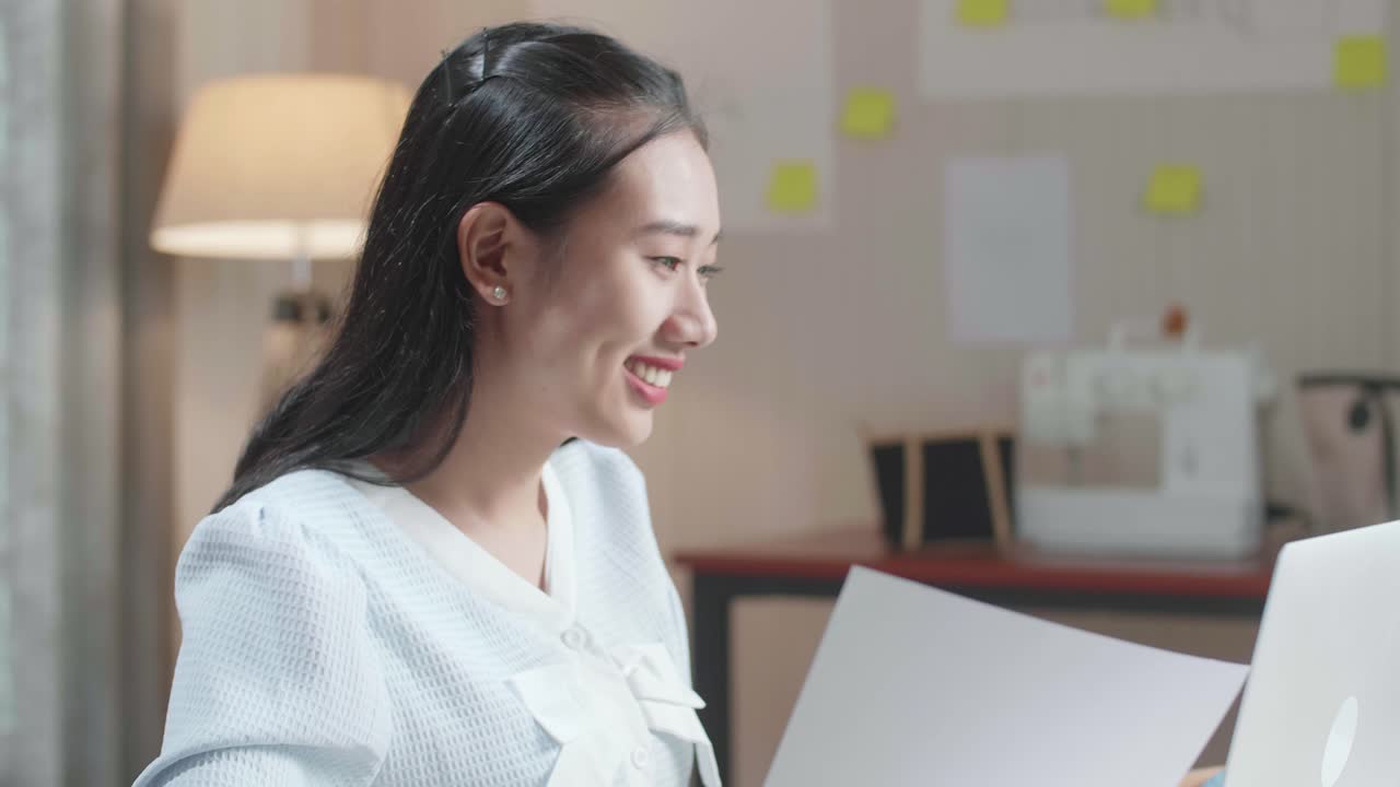 사무실에서 노트북으로 작업하는 동안 레이아웃을 보는 아시아 여성 디자이너의 클로즈업