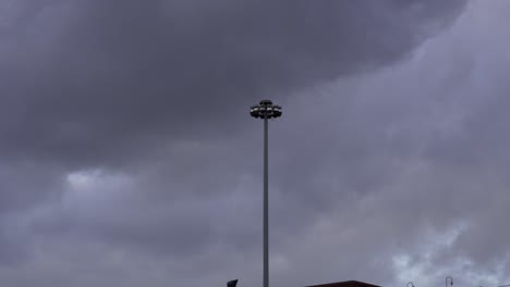 cámara lenta: la tormenta se acerca, un poste de luz en el medio del cuadro está temblando por el intenso viento