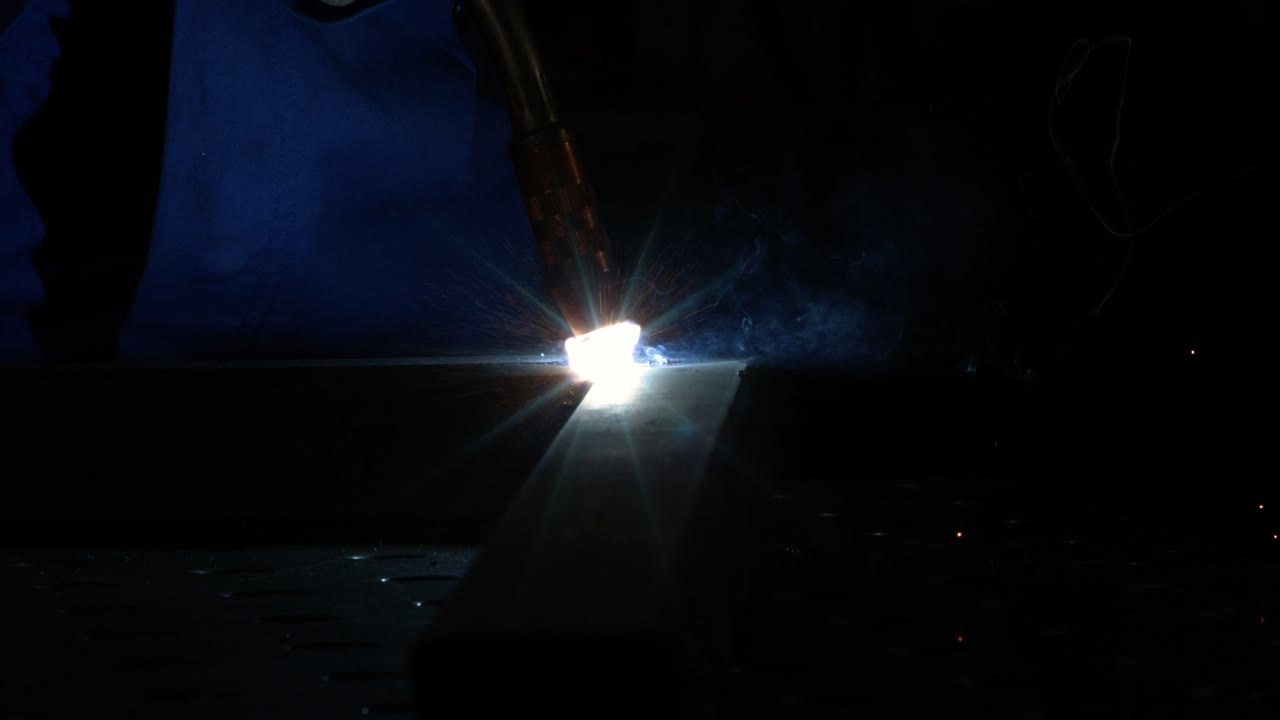 primer plano de una máquina de soldadura magnética que comienza a soldar en súper cámara lenta con fondo industrial