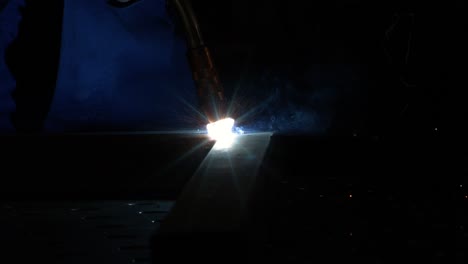 primer plano de una máquina de soldadura magnética que comienza a soldar en súper cámara lenta con fondo industrial