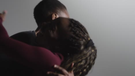 Studio-Shot-Of-Two-Women-Wearing-Gym-Fitness-Clothing-Hugging-And-Giving-High-Fives-After-Exercising