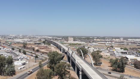 wide rising aerial shot of the california high-speed rail over the cedar viaduct in fresno, california. 4k